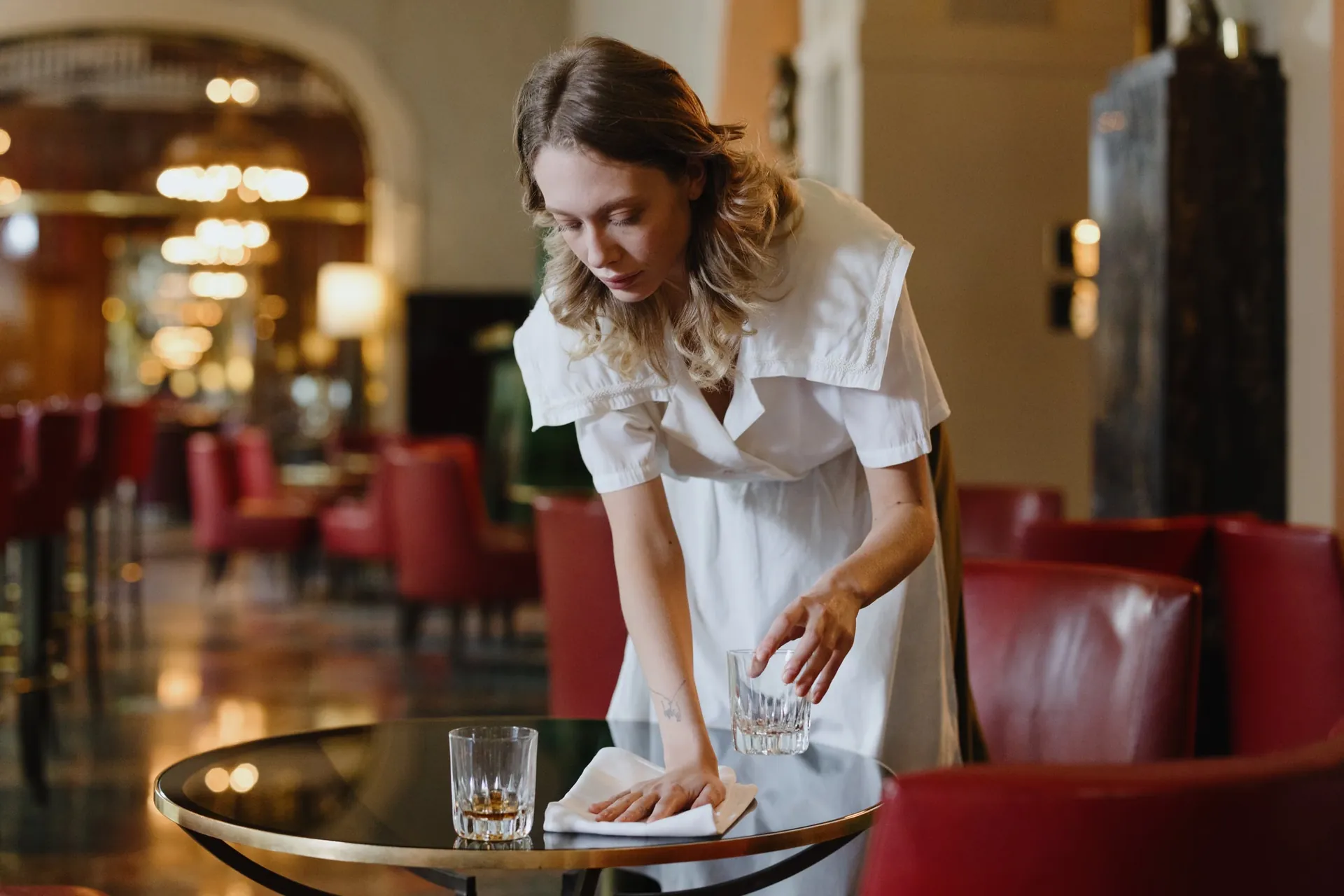 Une serveuse prépare une table avant le service (photo d'illustration)