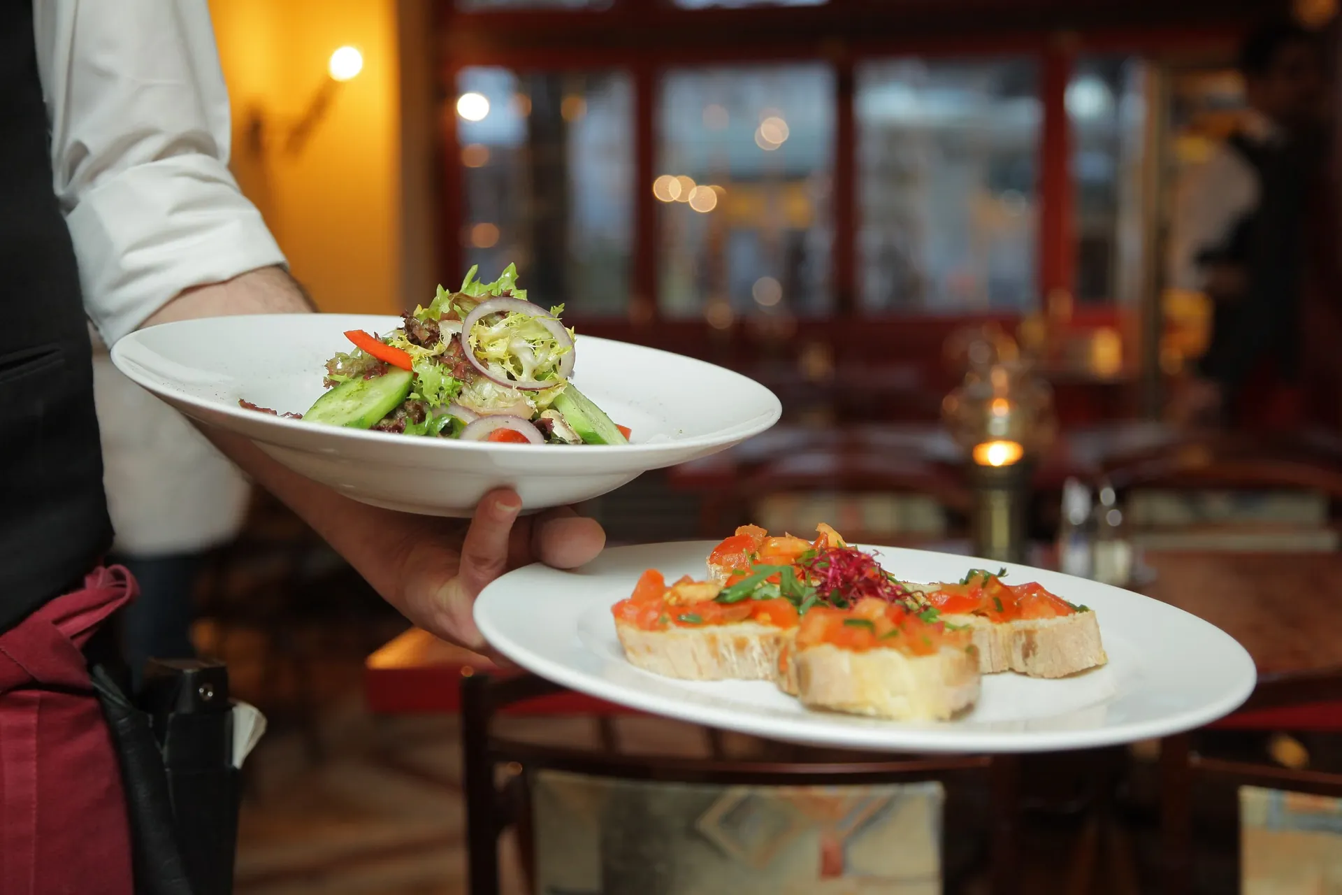 Un serveur apporte deux assiettes en salle (photo d'illustration)
